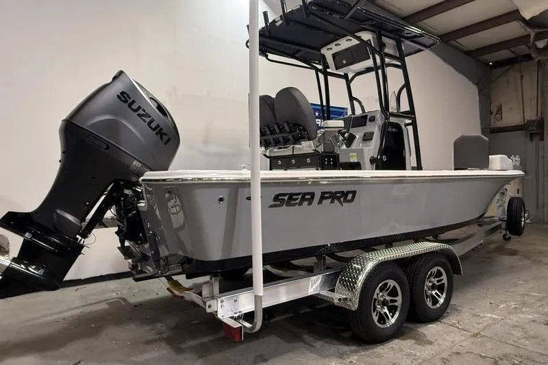 Slide: The Image of 2026 Sea Pro 230 Bay boat with Suzuki outboard motor on a trailer in a garage. - 3