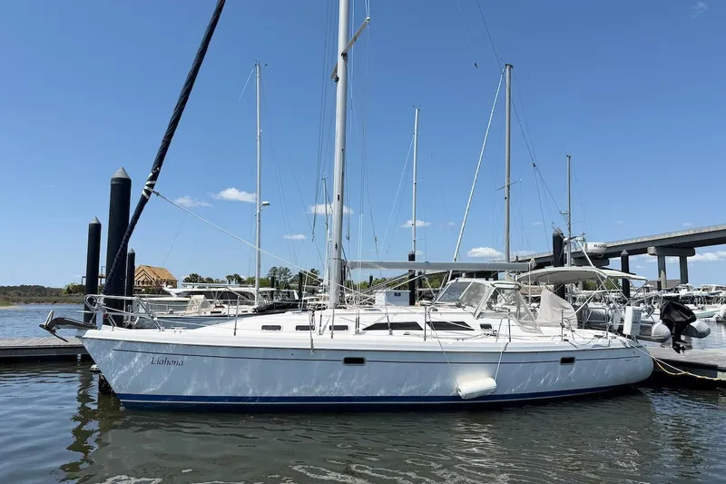 The Image of 1998 Catalina 380 sailboat docked at marina under clear blue sky. - 0