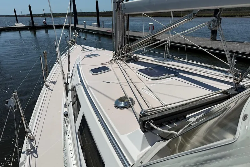 Slide: The Image of Sailboat deck of 1998 Catalina 380 docked at marina, showcasing rigging and hatches. - 11