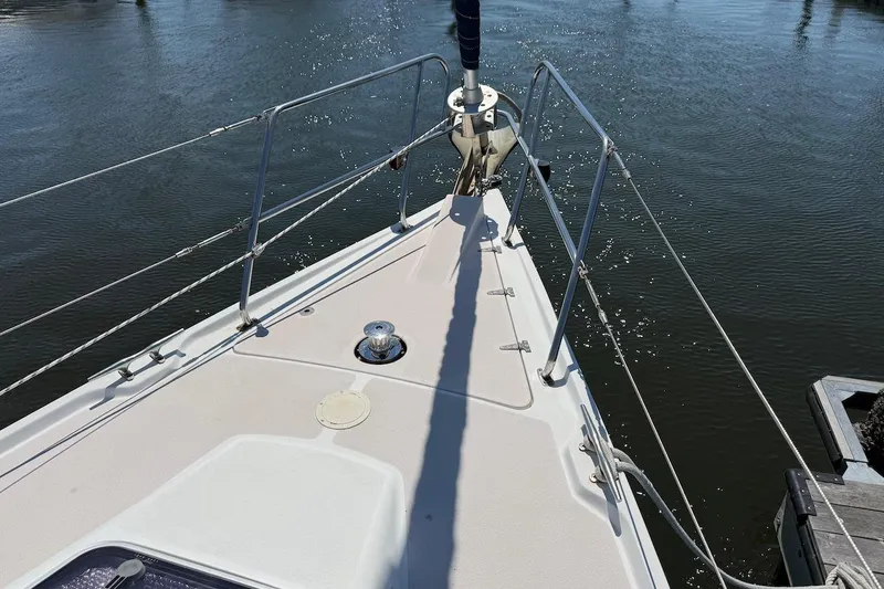 Slide: The Image of Bow view of a 1998 Catalina 380 sailboat on calm water. - 12