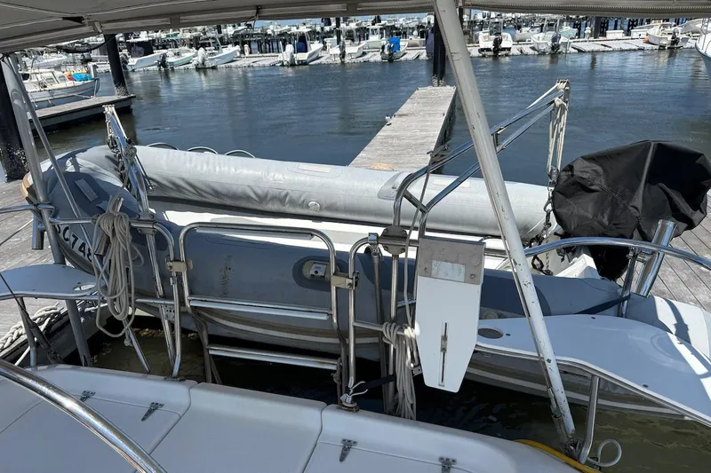 Slide: The Image of Catalina 380 sailboat from 1998 docked with inflatable dinghy at marina. - 14