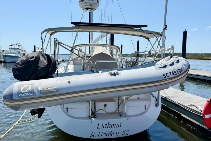 Slide: The Image of Catalina 380 sailboat from 1998 docked with Zodiac dinghy attached. - 2