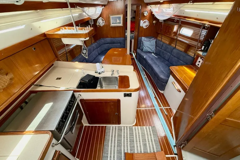 Slide: The Image of Interior of a 1998 Catalina 380 sailboat featuring a cozy kitchen and seating area. - 24