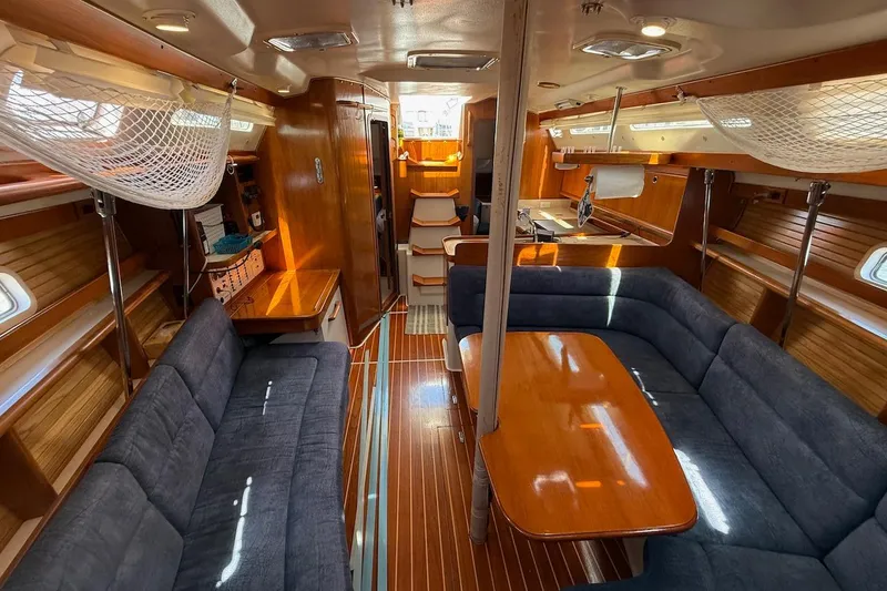 Slide: The Image of Interior of a 1998 Catalina 380 sailboat with wood finishes and blue seating. - 25