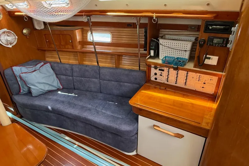 Slide: The Image of Interior of a 1998 Catalina 380 sailboat with blue sofa and navigation station. - 27