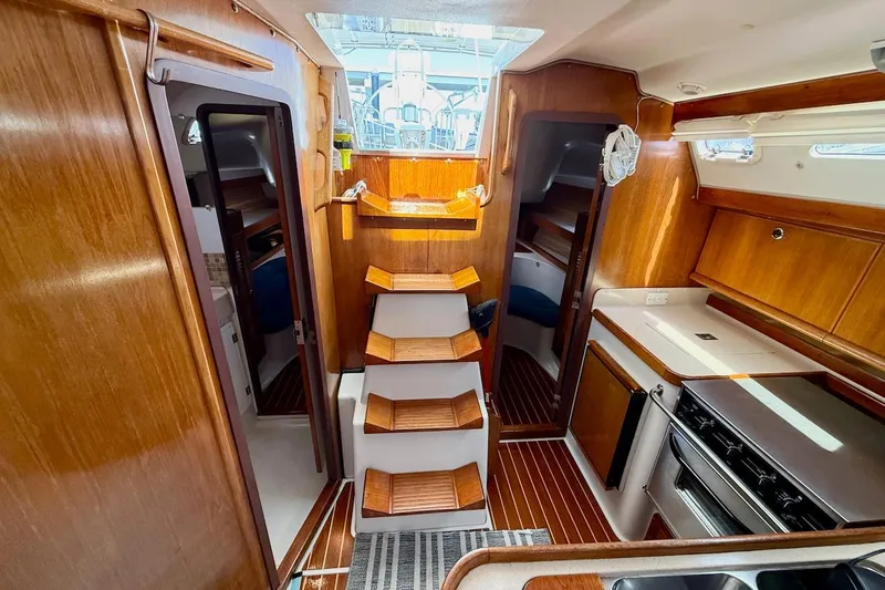 Slide: The Image of Interior of a 1998 Catalina 380 sailboat with wooden cabinetry and compact kitchen. - 28