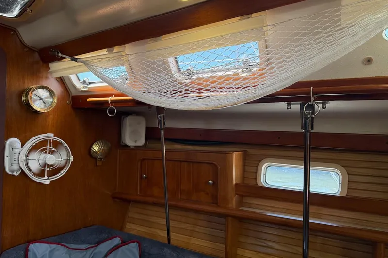 Slide: The Image of Interior of a 1998 Catalina 380 sailboat with wooden finish and storage netting. - 29
