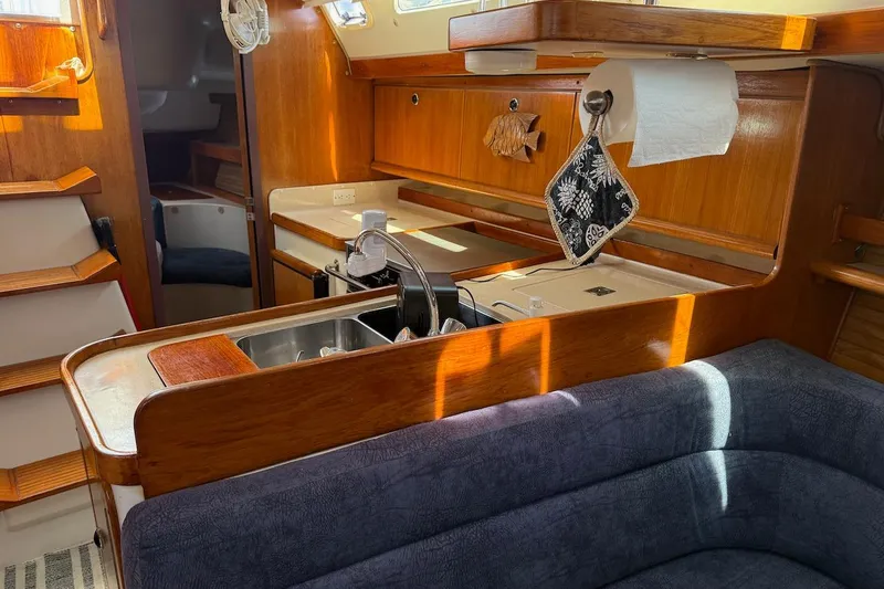 Slide: The Image of Interior of a 1998 Catalina 380 sailboat, featuring a cozy kitchen and seating area. - 30