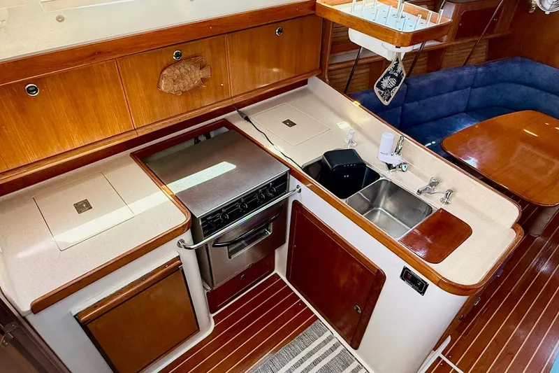 Slide: The Image of Interior of 1998 Catalina 380 yacht featuring a well-equipped galley and dining area. - 32