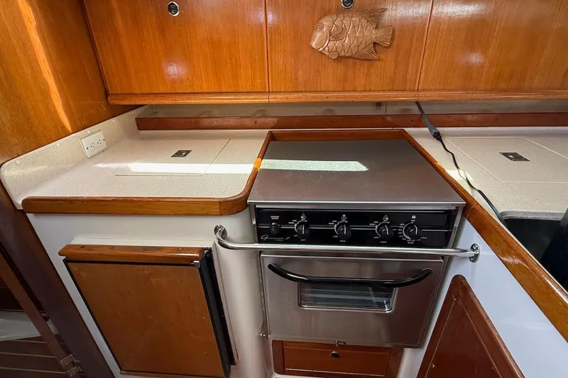 Slide: The Image of Galley kitchen in 1998 Catalina 380 sailboat with stove and wooden cabinetry. - 33