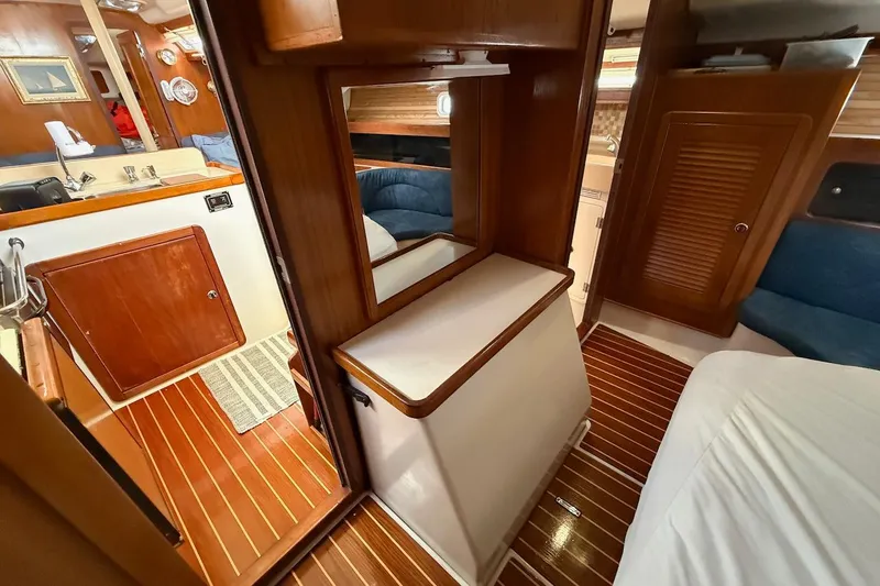 Slide: The Image of Interior of a 1998 Catalina 380 yacht, featuring wood paneling and compact living space. - 35