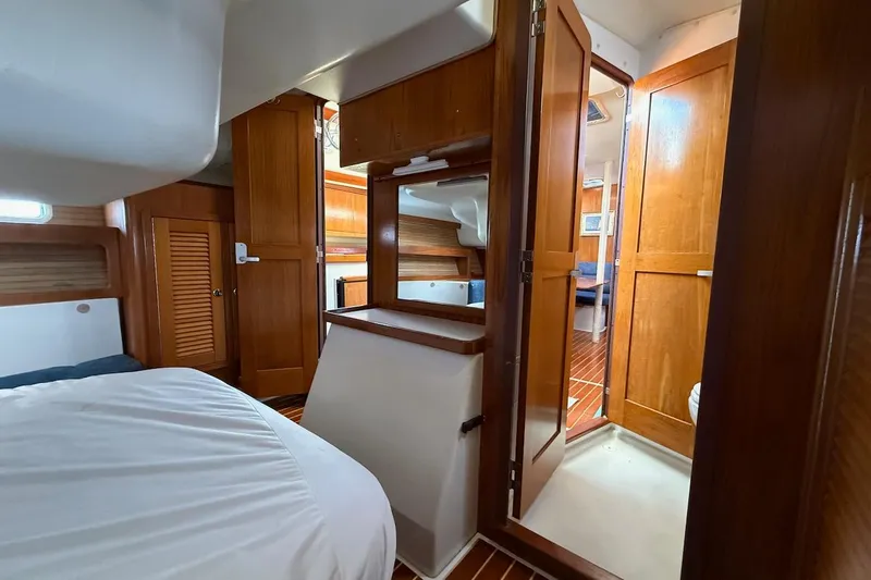 Slide: The Image of Interior of a 1998 Catalina 380 sailboat with wooden cabinetry and cozy sleeping quarters. - 36