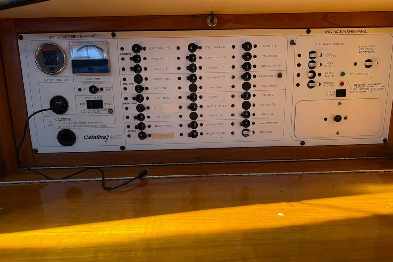 Slide: The Image of Electrical control panel of a 1998 Catalina 380 yacht, featuring various switches and gauges. - 40