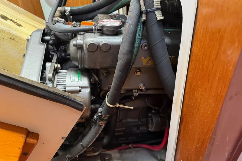 Slide: The Image of Engine compartment of a 1998 Catalina 380 sailboat, showcasing mechanical components and hoses. - 43