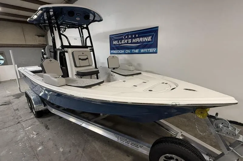 Slide: The Image of 2026 Sea Pro 230 Bay boat on trailer in showroom, Miller's Marine banner visible. - 2
