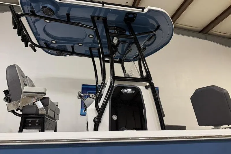 Slide: The Image of 2026 Sea Pro 230 Bay boat interior with seating and console, under a blue canopy. - 5