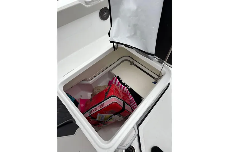 Slide: The Image of Storage compartment of 2024 Scarab 235 ID boat with life jackets inside. - 11