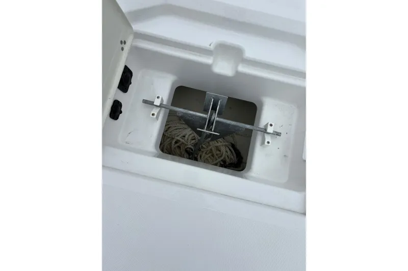 Slide: The Image of Anchor storage compartment on 2024 Scarab 235 ID boat, featuring rope and anchor. - 13