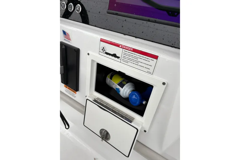 Slide: The Image of Control panel of 2024 Scarab 235 ID boat with storage compartment open. - 14