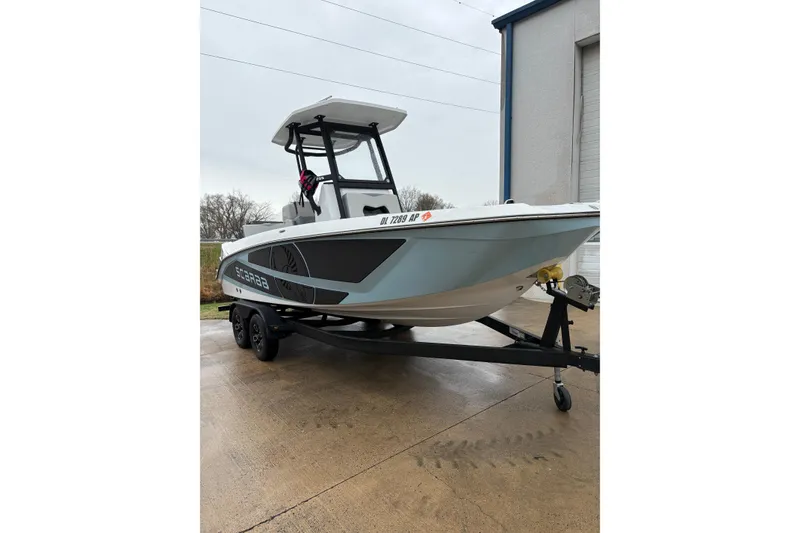 Slide: The Image of 2024 Scarab 235 ID boat on trailer, parked outside a building. - 4