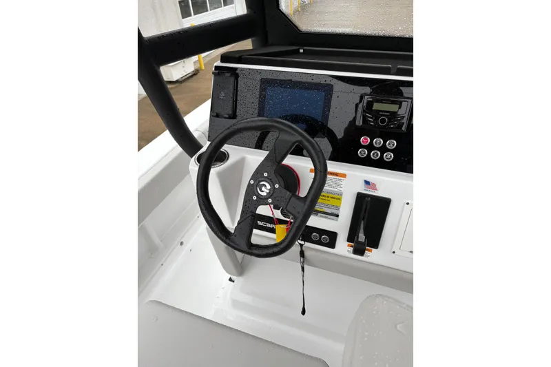 Slide: The Image of 2024 Scarab 235 ID boat dashboard with steering wheel and control panel. - 8