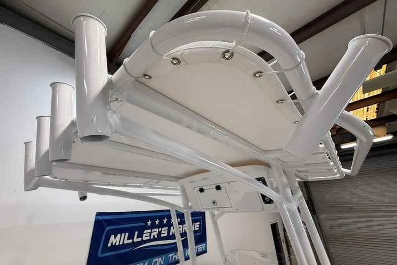 Slide: The Image of 2026 Sea Pro 230 Bay boat's T-top with rod holders in a showroom. - 11