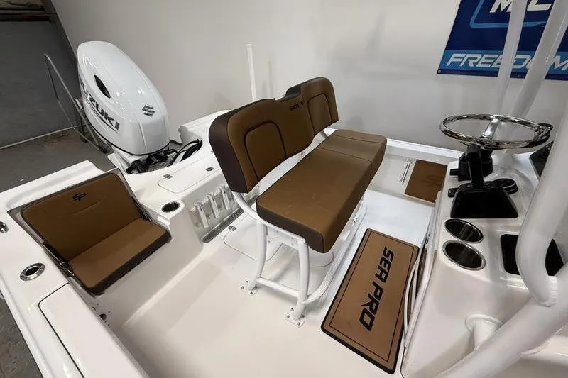 Slide: The Image of 2026 Sea Pro 230 Bay boat interior with brown seating and Suzuki engine. - 8