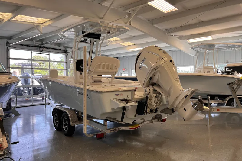 The Image of 2026 Tidewater 2500 Carolina Bay boat displayed in a showroom, featuring a powerful outboard motor. - 0