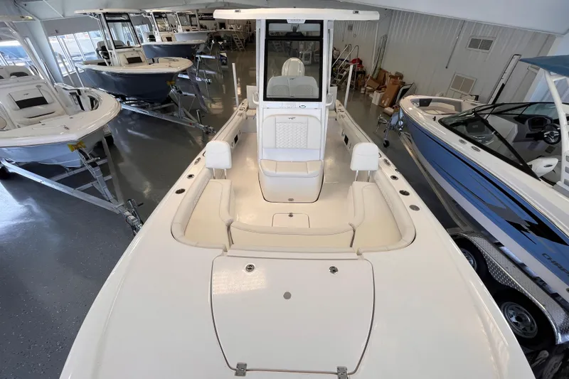 Slide: The Image of 2026 Tidewater 2500 Carolina Bay boat displayed in a showroom with other boats. - 11