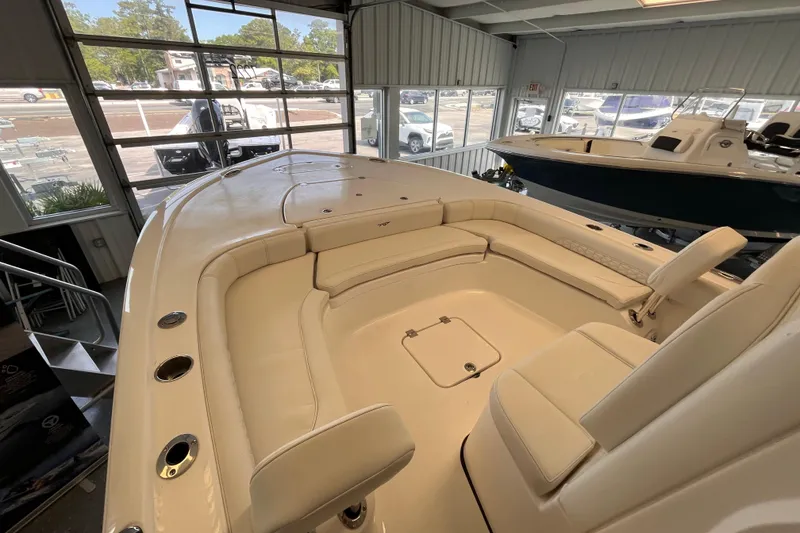 Slide: The Image of 2026 Tidewater 2500 Carolina Bay boat interior with beige seating in showroom. - 12