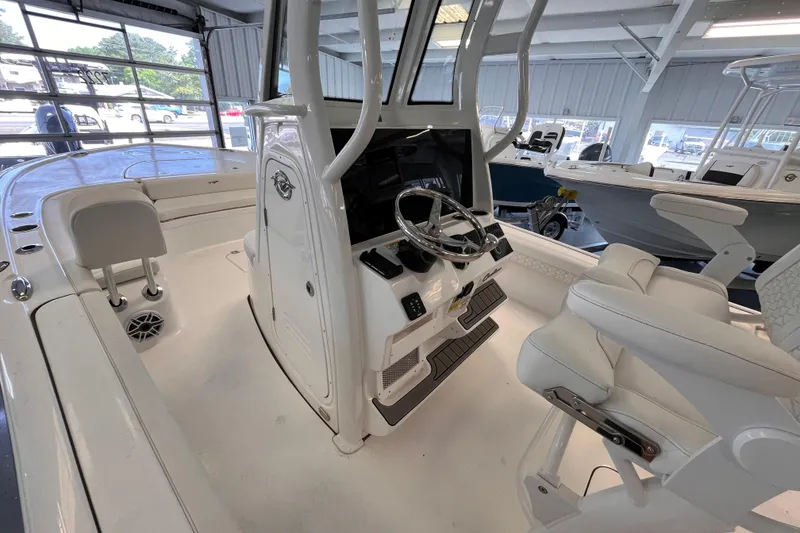 Slide: The Image of 2026 Tidewater 2500 Carolina Bay boat interior with modern helm and seating in showroom. - 13