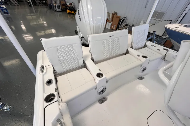 Slide: The Image of 2026 Tidewater 2500 Carolina Bay boat interior with white cushioned seating and cup holders. - 6