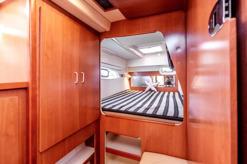 Slide: The Image of Cozy cabin interior of 2011 Leopard 39 yacht with striped bedding and wooden cabinetry. - 16