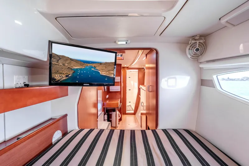 Slide: The Image of Interior of 2011 Leopard 39 yacht cabin with TV and striped bedding. - 17