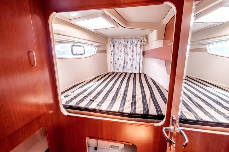 Slide: The Image of Cozy cabin interior of 2011 Leopard 39 yacht with striped bedding and wooden finish. - 21
