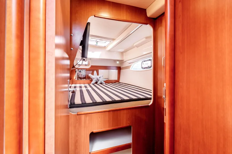 Slide: The Image of Cozy cabin interior of 2011 Leopard 39 yacht with striped bedding and wooden finish. - 24