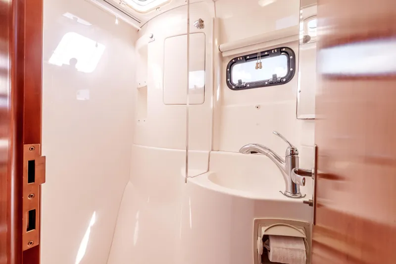 Slide: The Image of Bathroom interior of a 2011 Leopard 39 yacht, featuring a sleek sink and porthole window. - 26