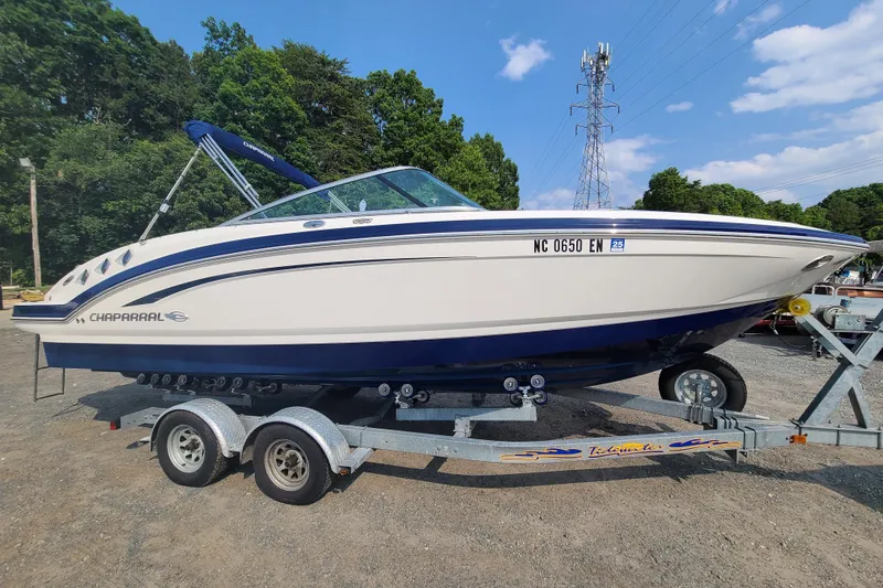 The Image of 2014 Chaparral 246 SSi boat on trailer, parked outdoors under clear sky. - 0