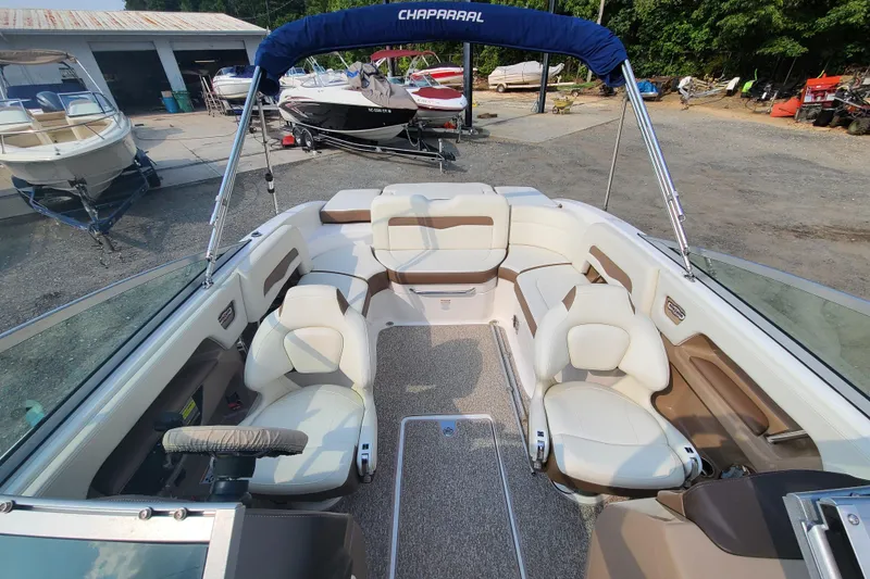 Slide: The Image of 2014 Chaparral 246 SSi boat interior with white seating and blue canopy. - 15