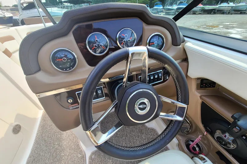 Slide: The Image of 2014 Chaparral 246 SSi boat dashboard with steering wheel and gauges. - 19