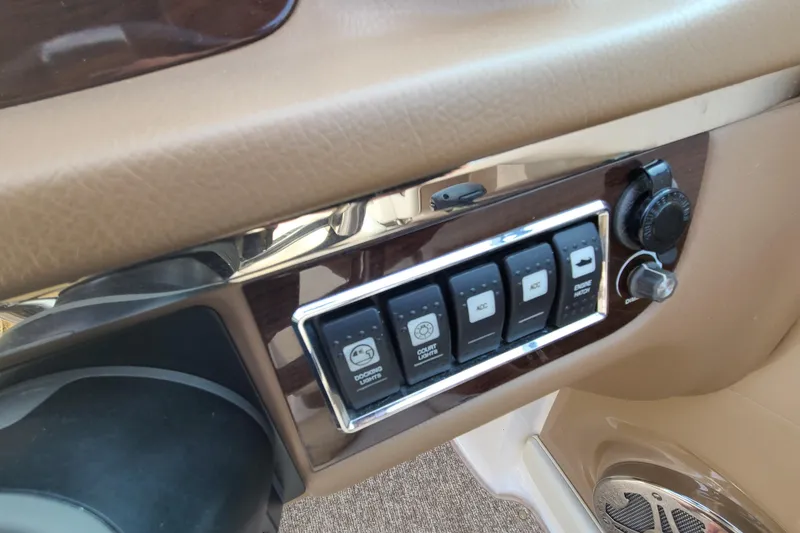 Slide: The Image of Control panel of a 2014 Chaparral 246 SSi boat with switches and knobs. - 23