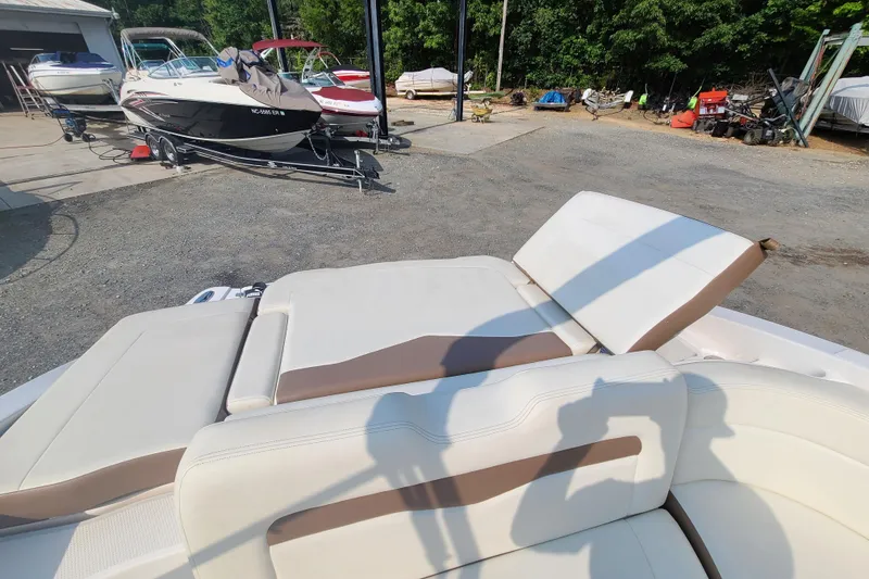 Slide: The Image of 2014 Chaparral 246 SSi boat with beige seating, parked among other boats. - 30