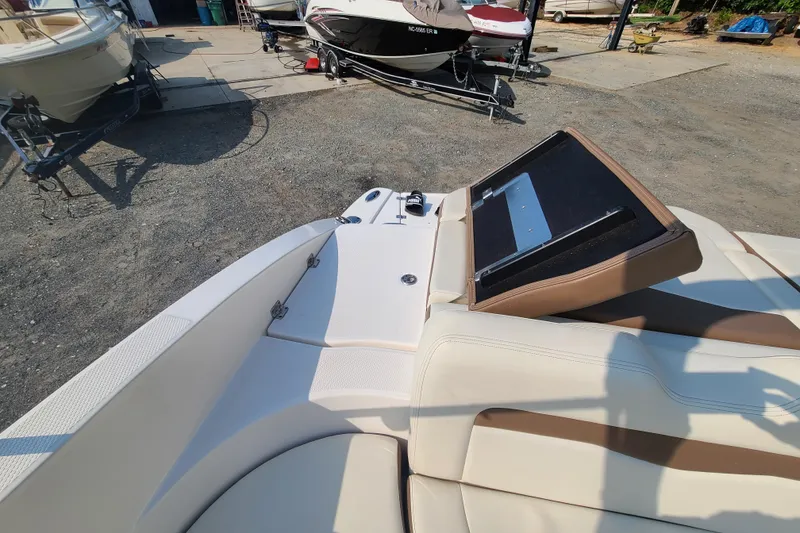 Slide: The Image of 2014 Chaparral 246 SSi boat interior with beige and brown seating, docked outdoors. - 31