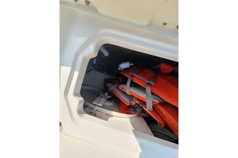 Slide: The Image of Storage compartment with life jackets on a 2014 Chaparral 246 SSi boat. - 32