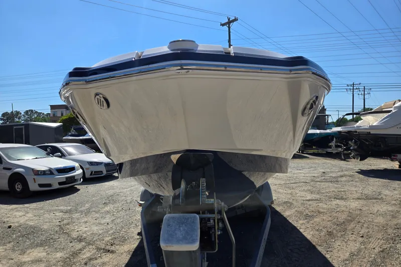 Slide: The Image of 2014 Chaparral 246 SSi boat on trailer, parked outdoors under clear blue sky. - 45