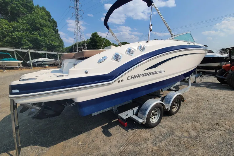 Slide: The Image of 2014 Chaparral 246 SSi boat on trailer, parked outdoors under clear sky. - 5