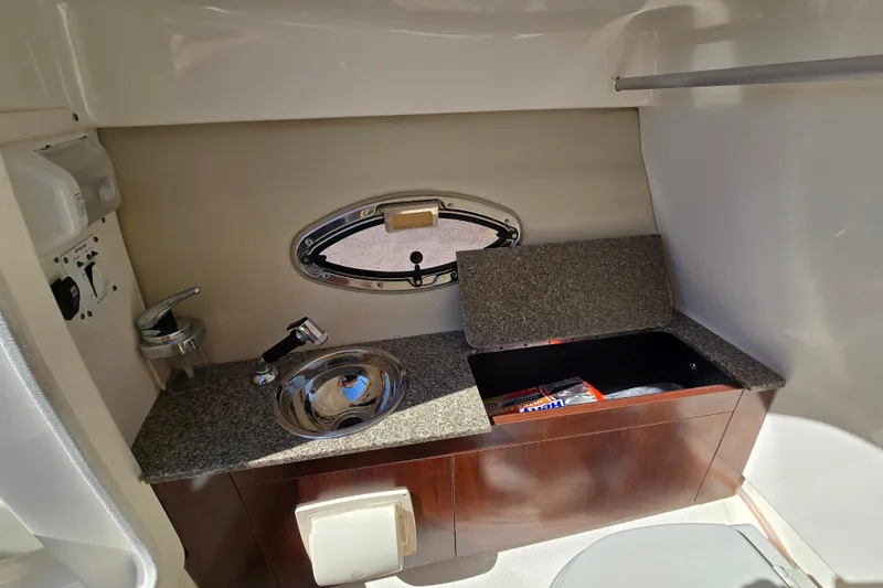 Slide: The Image of 2014 Chaparral 246 SSi boat interior with sink, storage, and porthole window. - 56