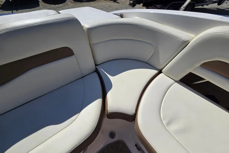 Slide: The Image of 2014 Chaparral 246 SSi boat interior with white and brown cushioned seating. - 62