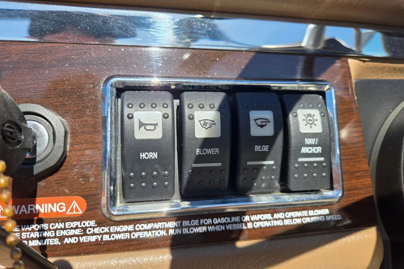 Slide: The Image of Control panel of a 2014 Chaparral 246 SSi boat with horn, blower, bilge, and navigation switches. - 64