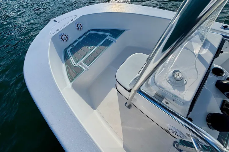Slide: The Image of 2024 Tidewater 180 CC Adventure boat deck with speakers and seating, on water. - 13